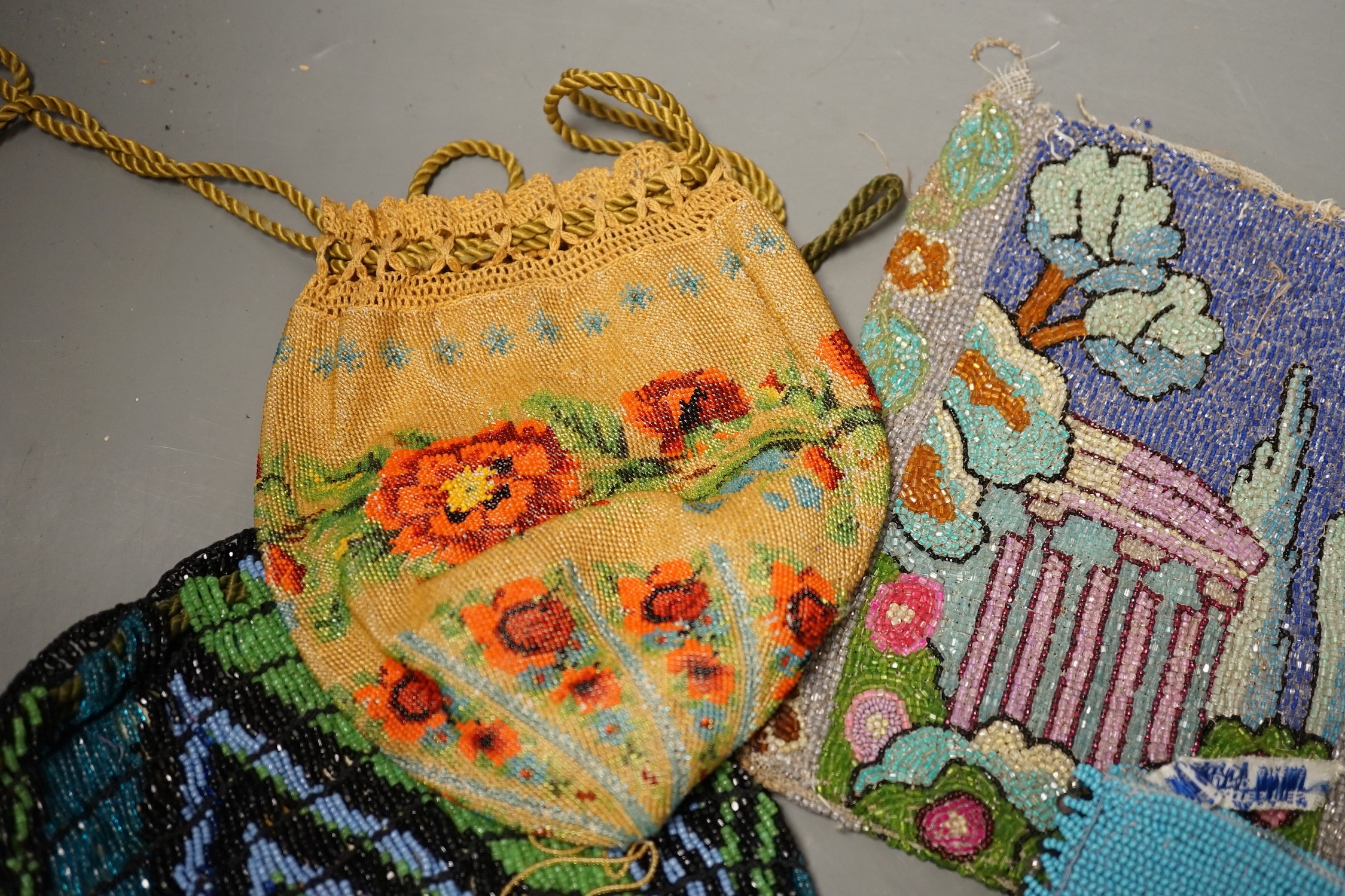 A late 19th century floral bead worked drawstring bag, a later jazz age beaded bag, a turquoise plain bead bag with zip and an unlined bead bag with a classical scene, (4)